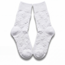 Flat lay of white Money Socks crew socks standing upright, displaying the embossed 3D dollar-sign pattern down each leg